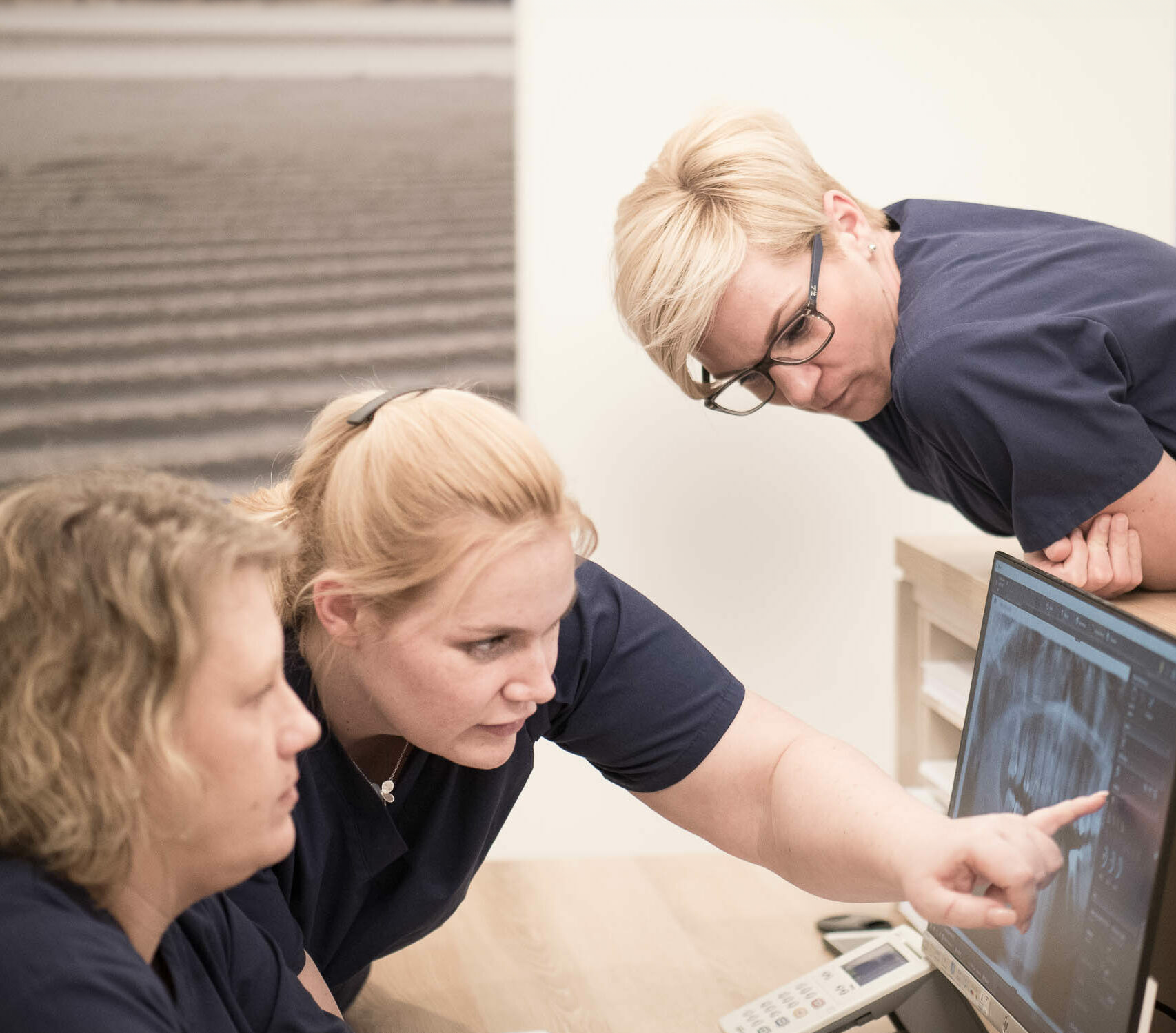 Zahnmedizinisches Team der Boddenchirurgie Ribnitz-Damgarten, drei Frauen schauen auf einen PC